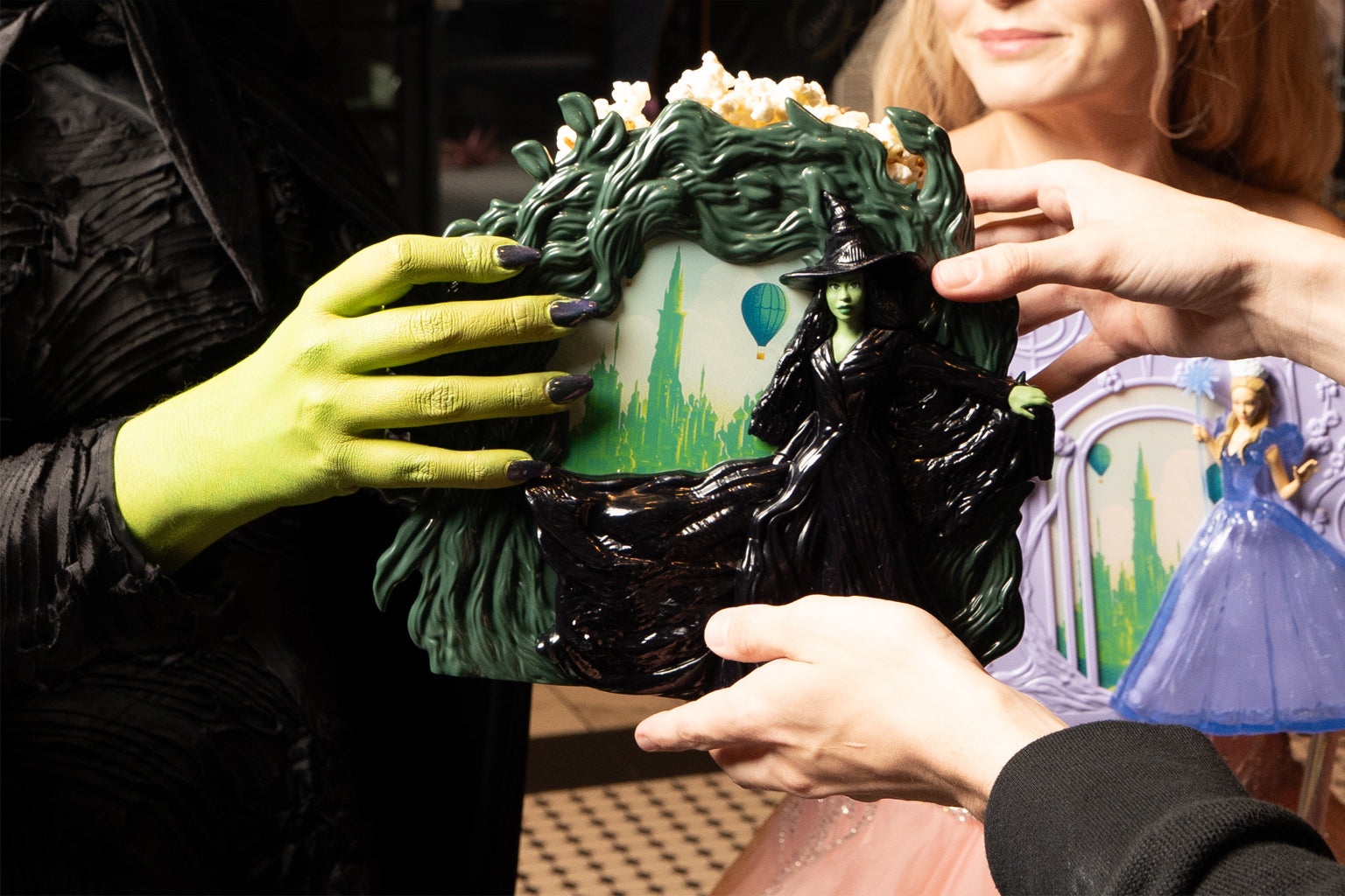 two people holding the WICKED: FOR GOOD Elphaba Popcorn Bucket
