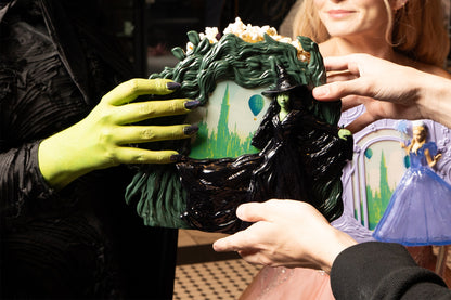 two people holding the WICKED: FOR GOOD Elphaba Popcorn Bucket