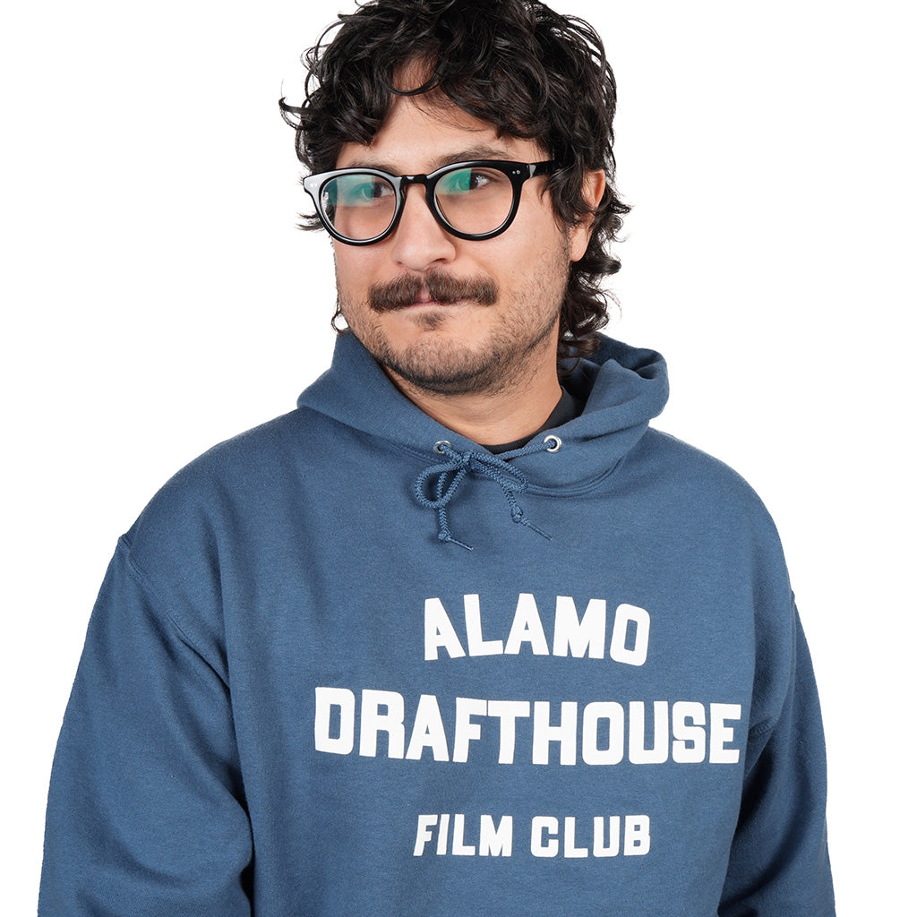 close-up of man wearing Alamo Drafthouse Film Club Hoodie in denim blue