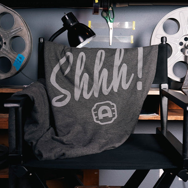Alamo Drafthouse SHHHHHH! Sweatshirt Blanket draped over a director's chair