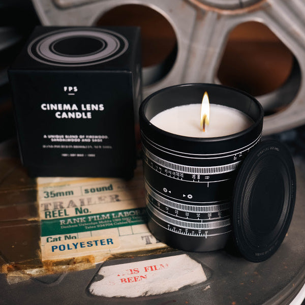 lit Cinema Lens Candle on top of a film canister